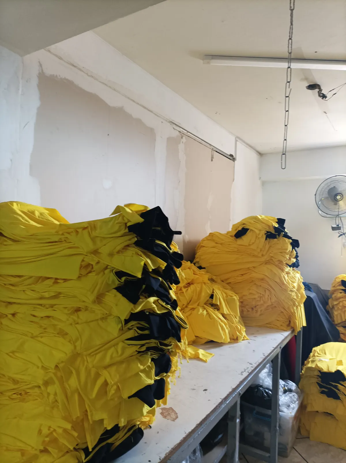 Polos corporativos amarillos doblados en el taller